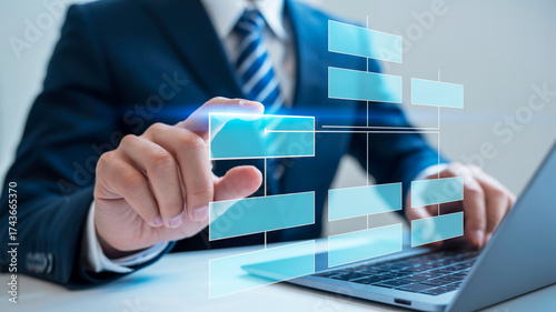 Person in suit interacting with a digital flowchart on a laptop business organization