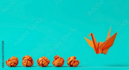 This vibrant image symbolizes transformation and creative evolution. Multiple crumpled orange paper balls are neatly arranged on a white line, progressively leading towards a beautifully folded orange