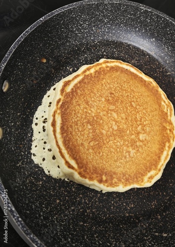Vista de cerca de pancake casero cocinándose en sartén para desayunar