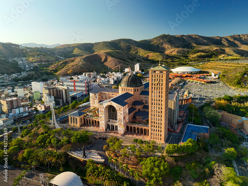 aerial view of the Basilica of the National Shrine of Our Lady Aparecida in Brazil during sunrise with mountains and greenery at distance