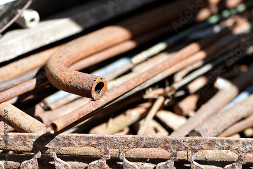old rusty iron pipes. old iron. scrap metal. Background photo of piles of old rusty iron pipes from industrial waste that have not been used for years. oxidized iron, cut small diameter tube