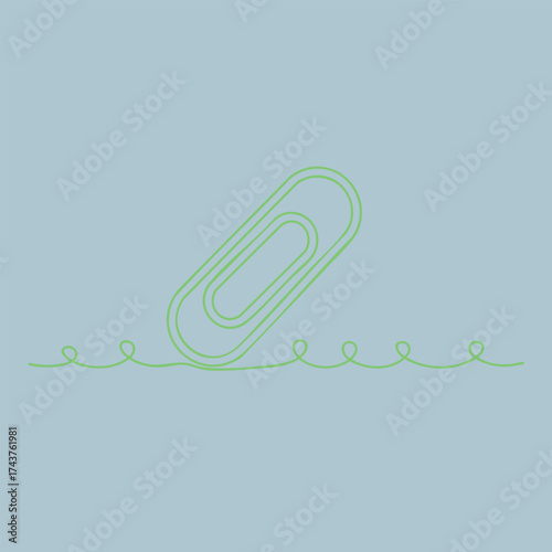 Close-up of a green paperclip partially submerged in water with ripples on a light blue