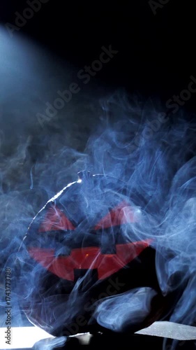 Halloween pumpkin smile and scary eyes for a party surrounded by smoke