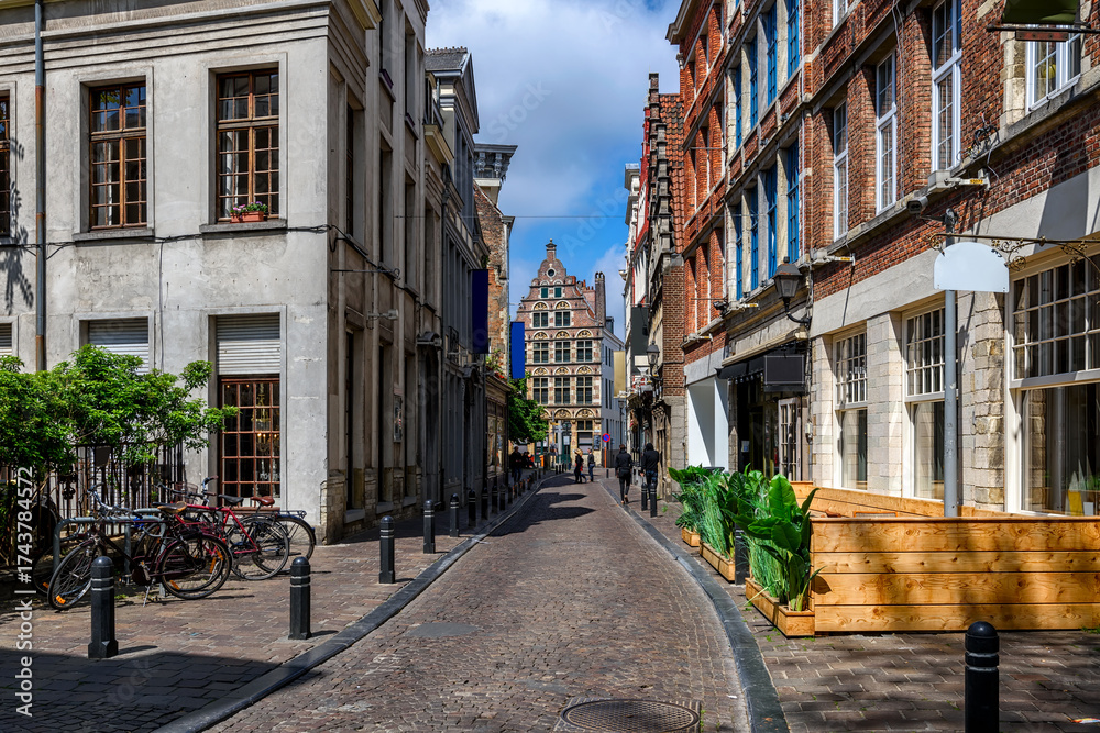 Obraz premium Old narrow street with tables of cafe in Ghent (Gent), Belgium. Architecture and landmark of Ghent. Cozy cityscape of Ghent.