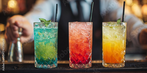 Colorful cocktails served at bar, showcasing vibrant drinks with mint leaves and ice, creating refreshing atmosphere