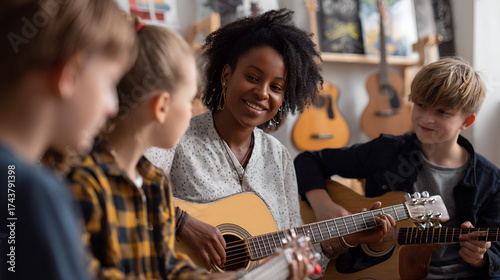 Teacher  kids playing guitars in music room guitars in the background