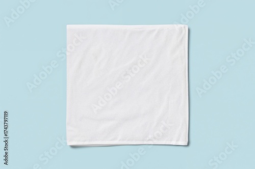 Square white cotton towel fabric wiper mockup isolated on soft pastel blue background, flat lay top view for hand and face cloth templates