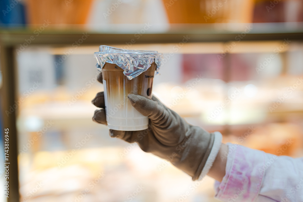 Obraz premium hand of woman holding a take-out iced with blurred bokeh blackground, isolate concept.