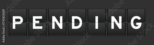Black color analog flip board with word pending on gray background