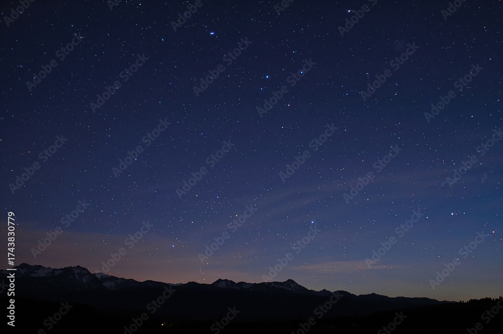 Naklejka premium Star trails over mountain landscape during nighttime