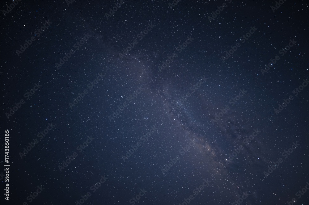 Fototapeta premium Extended exposure shot capturing the star-filled night sky and the Milky Way galaxy.