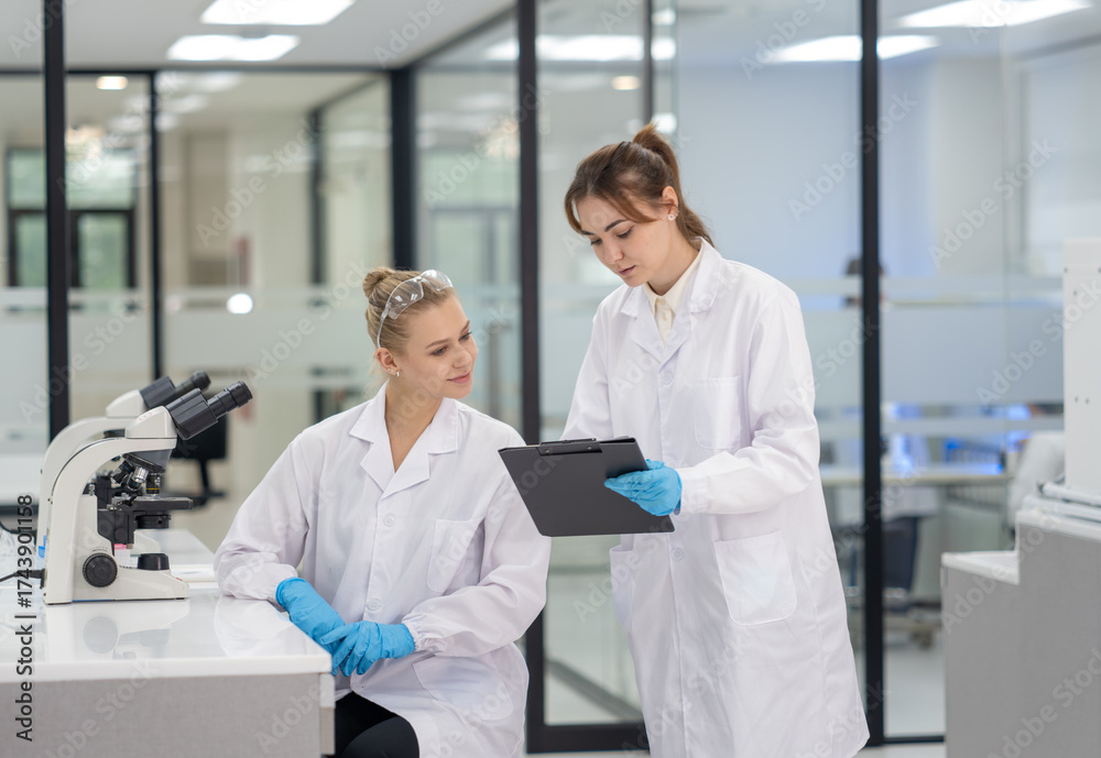 Obraz premium Two scientists discussing research data in a modern laboratory setting during daytime