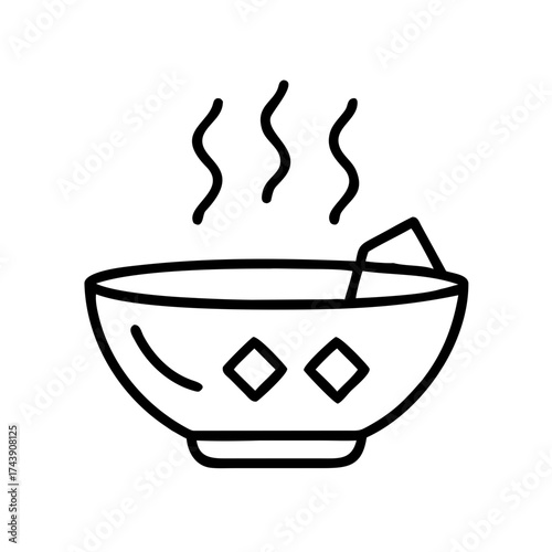 Bowl of steaming miso soup with floating tofu cube  