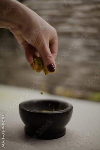 Woman's hand sprinkling spices in a kitchen