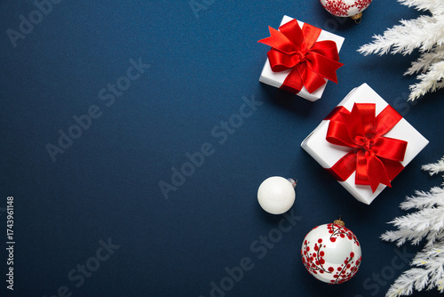 Merry Christmas and Happy Holidays greeting card, frame, banner. New Year. Red and white Christmas decorations and gifts on blue background top view. Winter xmas holiday celebration theme.	
