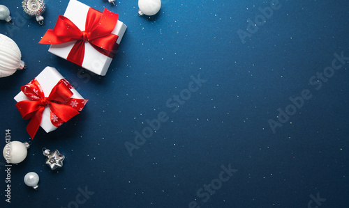 Merry Christmas and Happy Holidays greeting card, frame, banner. New Year. Red and white Christmas decorations and gifts on blue background top view. Winter xmas holiday celebration theme.	
