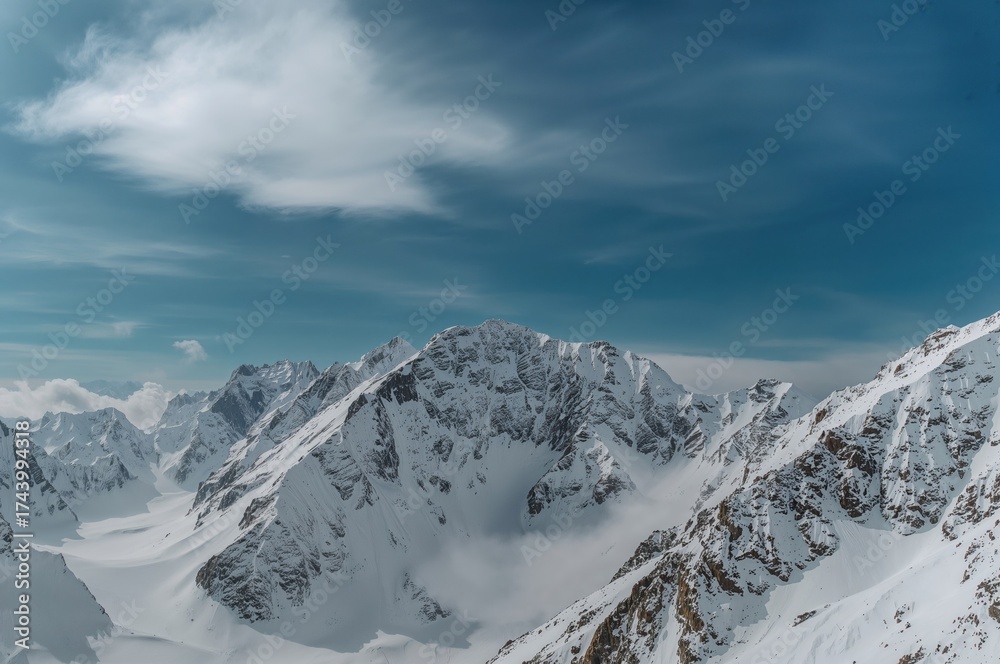 Obraz premium Snow-capped peaks beneath a bright azure sky, showcasing nature's raw splendor and tranquil white blankets.