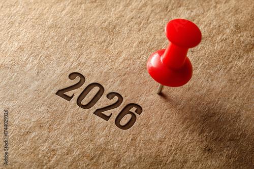 Red pin marks year 2026 on brown paper