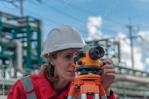 Woman engineer using theodolite outdoors