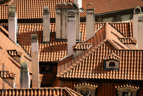 Foto Traditional red tiled rooftops and chimneys of historic residential buildings in