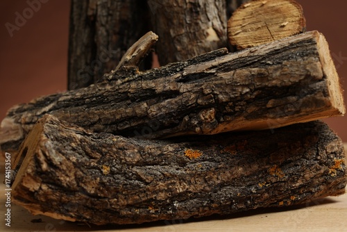 Wallpaper Mural Pile of cut firewood on wooden table against brown background, closeup Torontodigital.ca