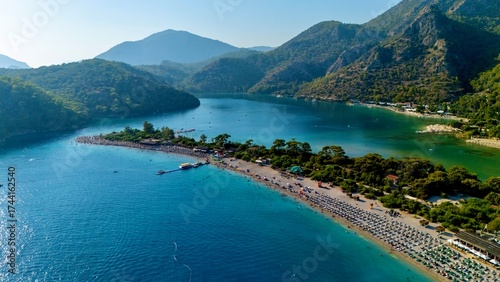 Fototapeta Naklejka Na Ścianę i Meble -  Aerial drone view of the Blue Lagoon in Oludeniz, Fethiye, Turkey with turquoise water, sandy beach, sunbeds, umbrellas and green mountains in summer.
