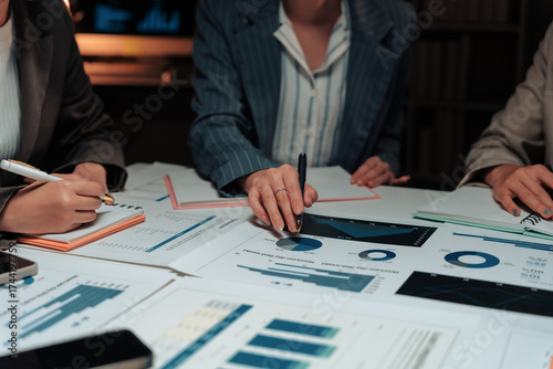 Businesswomen working late in the office, analyzing financial data and discussing growth opportunities