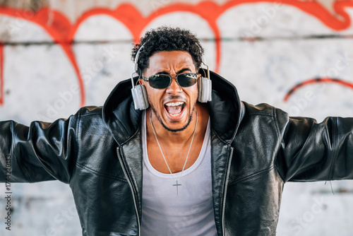 Bild auf Leinwand euphoric young man with headphones dancing in the street