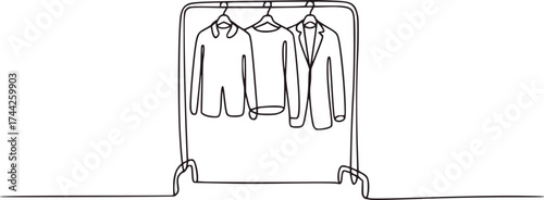 Three garments on hangers on a rack clothing apparel