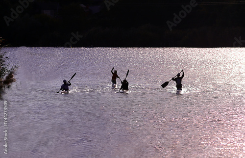 Evening start of boys on kayaks and canoes... silhouettes.
