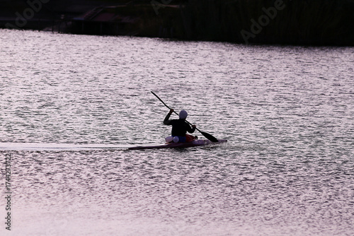 A rower performs a turn in a kayak in the evening breeze....