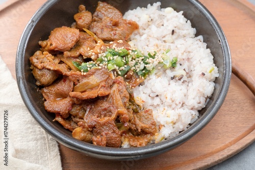 Jeyukdeopbap, Korean Food Spicy Stir-fried Pork with Rice in Black Bowl 