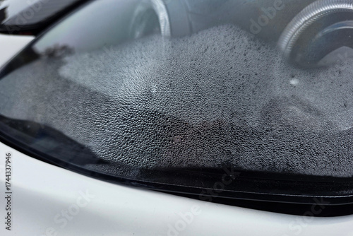 Moisture collects on the surface of a car windshield
