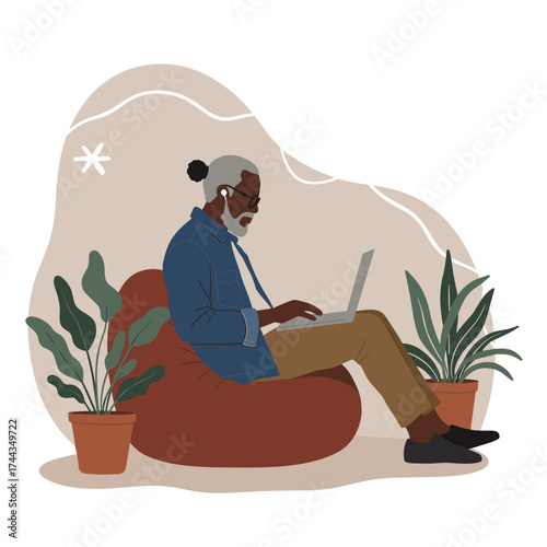 Elderly man uses laptop for remote work in a relaxed modern home office environment