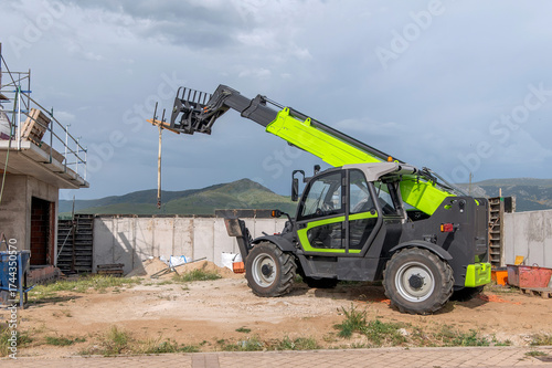 Forklift on a construction site, preparing to raise construction parts