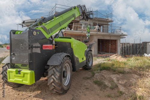 Forklift on a construction site, preparing to raise construction parts