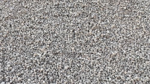 Dynamic footage of gravel surface movement under natural light, representing foundation materials for road and landscape projects.