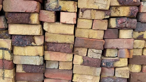 Video showing a stack of rustic clay bricks with natural imperfections and warm earthy tones. Perfect for construction, industrial, or architectural footage.