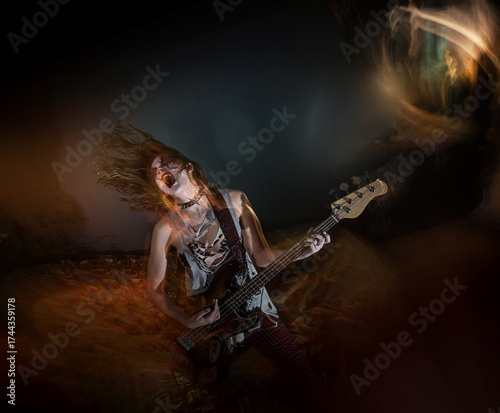 A female rocker with gothic makeup performing metal music during Halloween