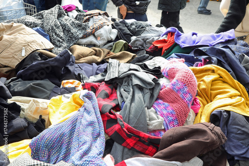 Foto Disorganized stack of various pre owned fashion garments and outfits at an open