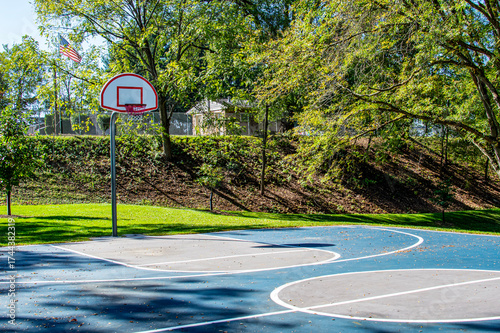 Outdoor basketball court with hoop and trees