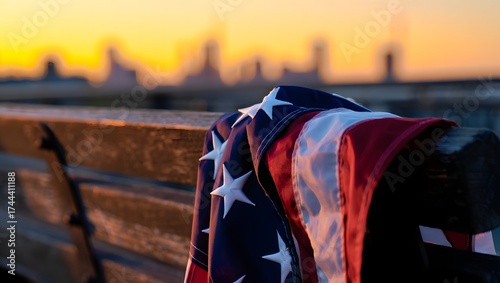 American flag draped over railing with new york city skyline at sunset