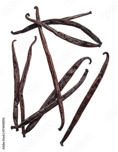 Dark, aromatic vanilla bean pods in various orientations against a stark black background