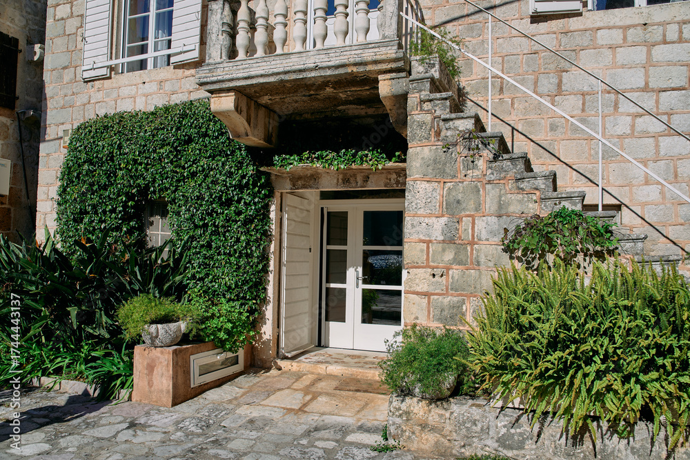 Fototapeta premium Charming Stone Entrance with Lush Greenery and Decorative Elements Surrounded by Naturals Features and Classic Architecture