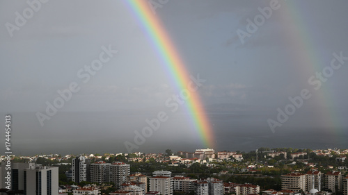 Colorful Double Rainbow Appearing After Rainstorm Over Town