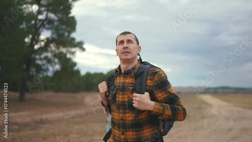 man and woman traveling. active tourism and travel around the world concept. two tourists, man and woman traveling with backpacks on lifestyle their backs, walking along a road in the forest