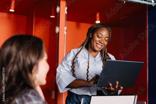 Diverse woman guiding a team discussion in a tech company 