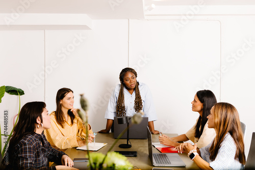 A black female professional conducting a collaborative meeting