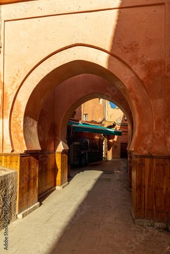 Sunlit Moroccan archway in narrow medina alley

