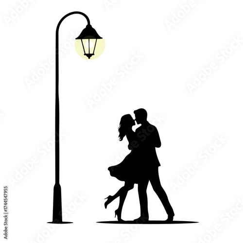 Romantic couple silhouette dancing together under a street light.